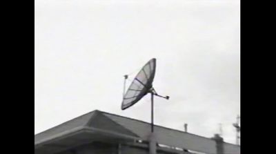 a black and white photo of a satellite dish on top of a building