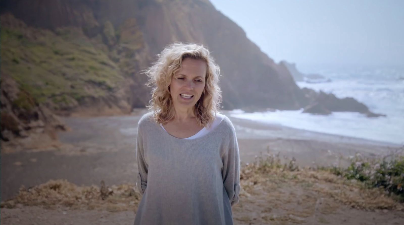 a woman standing on a beach next to the ocean