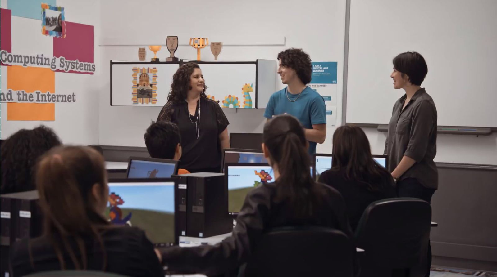 a group of people standing in front of a whiteboard