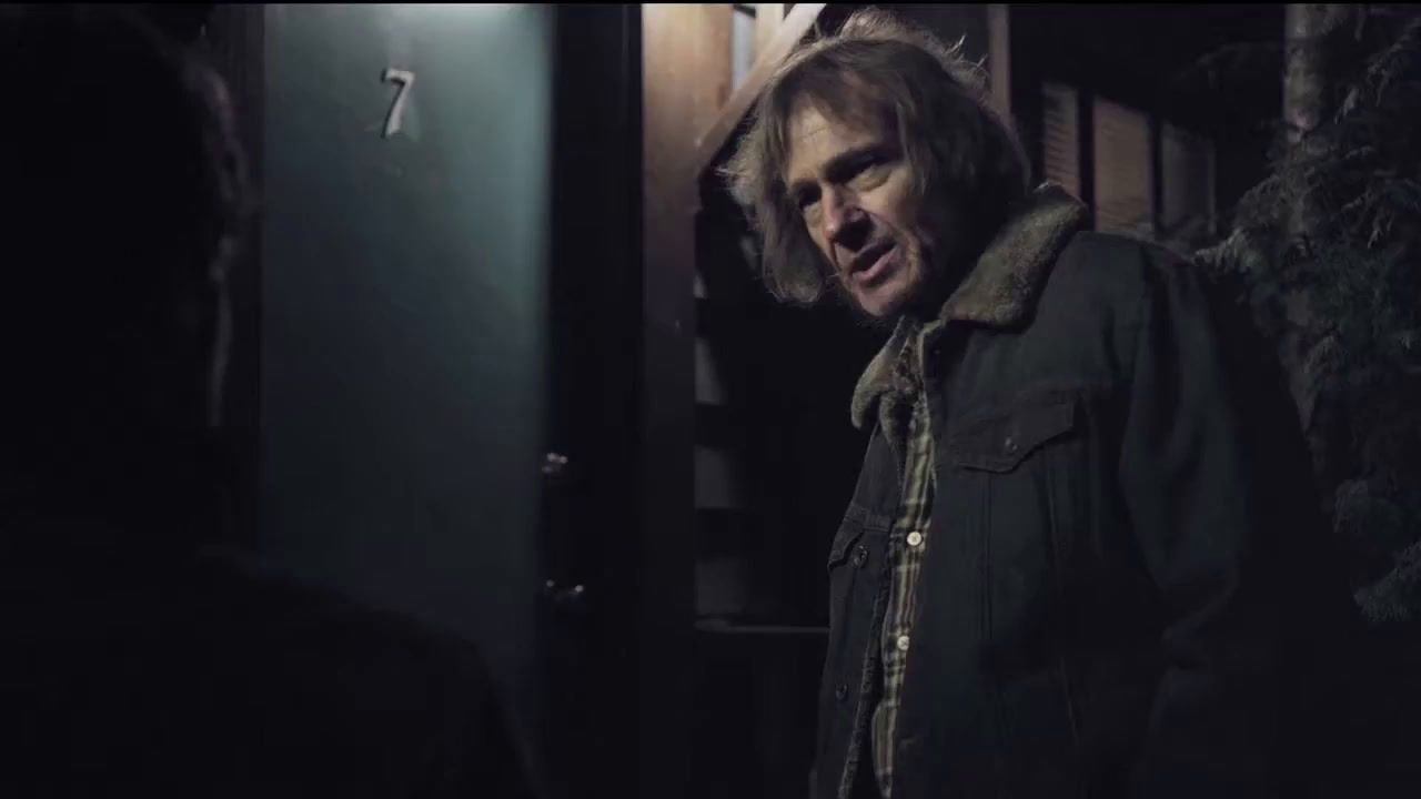 a man standing next to a door in a dark room