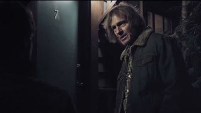 a man standing next to a door in a dark room
