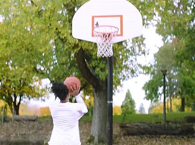 a man is playing basketball in a park