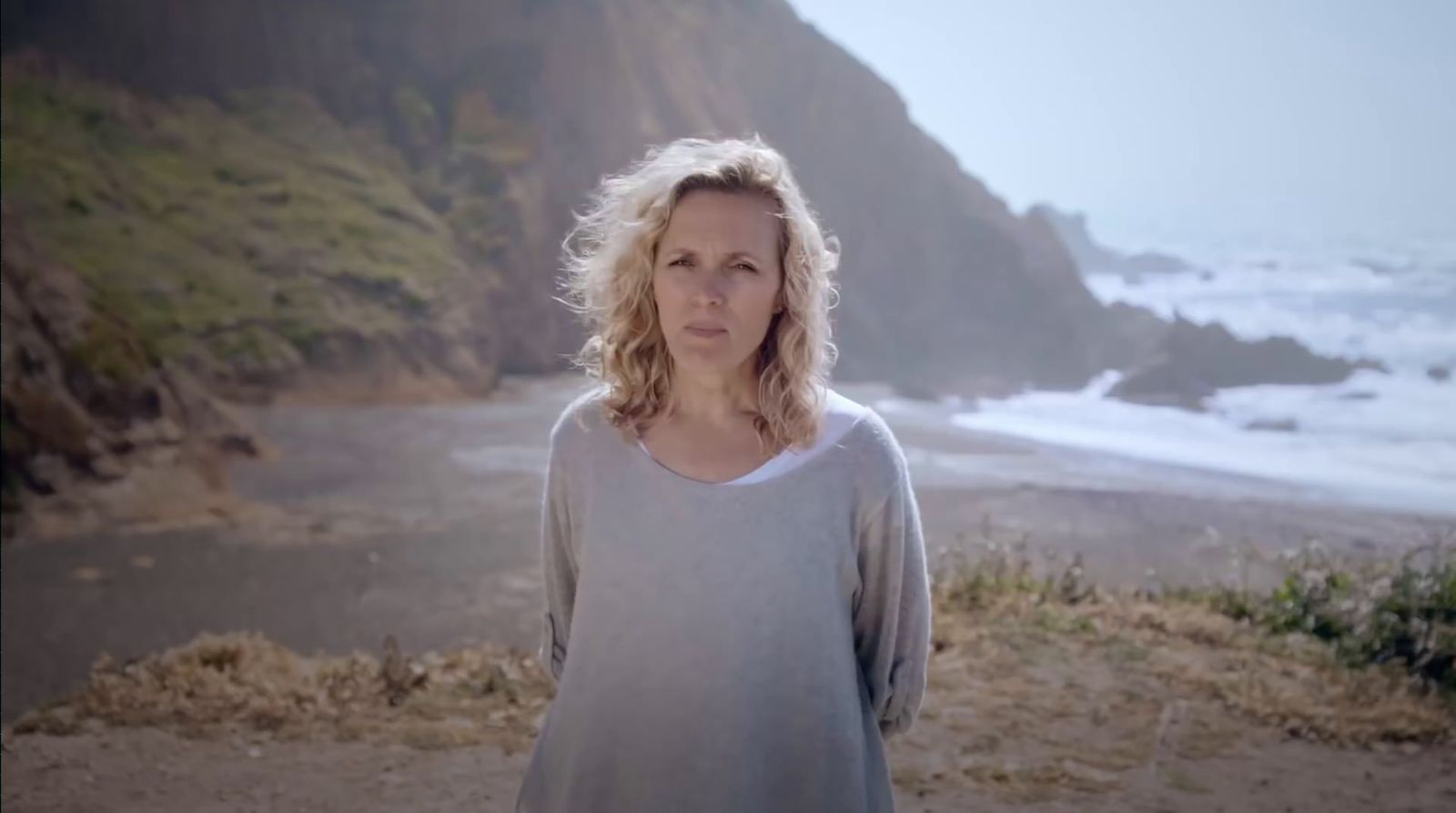 a woman standing on a beach near the ocean