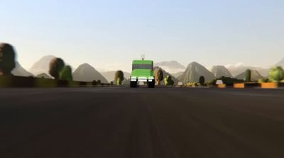 a green truck driving down a street next to mountains