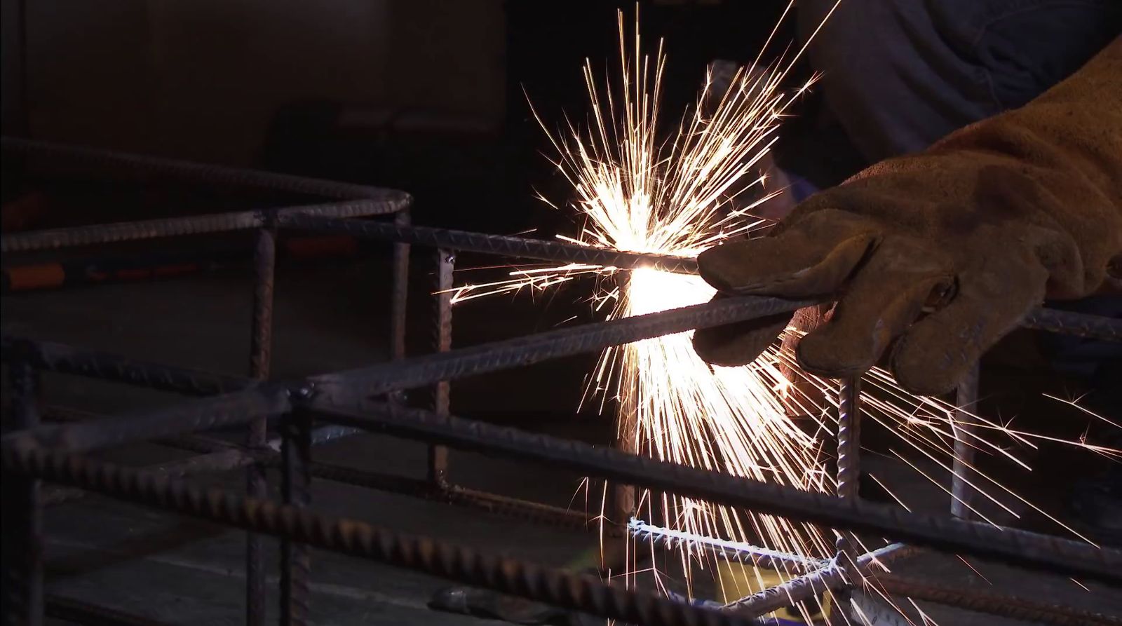 a person holding a piece of metal with sparks coming out of it