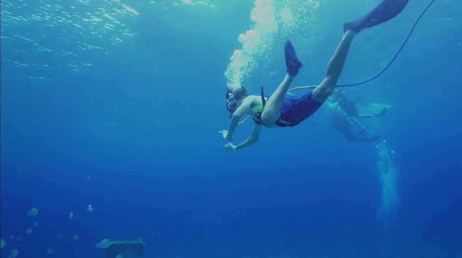 a woman is swimming in the ocean with a rope