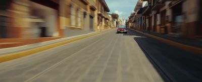 a car driving down a street next to tall buildings