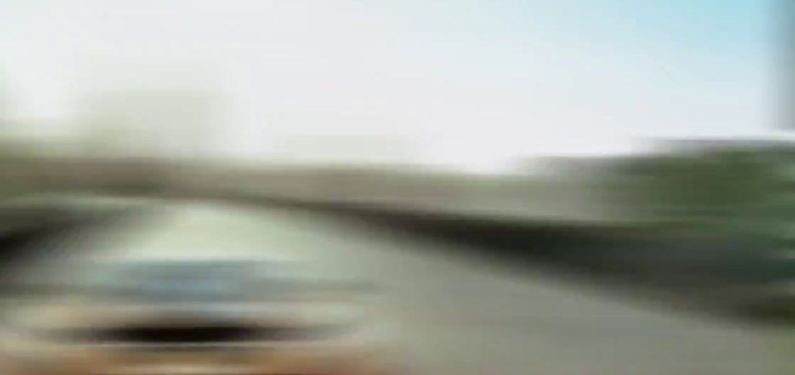 a blurry picture of a car driving down a street