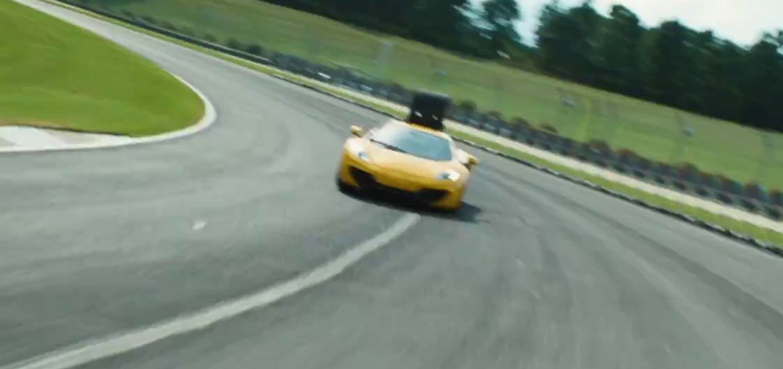 a yellow sports car driving down a race track