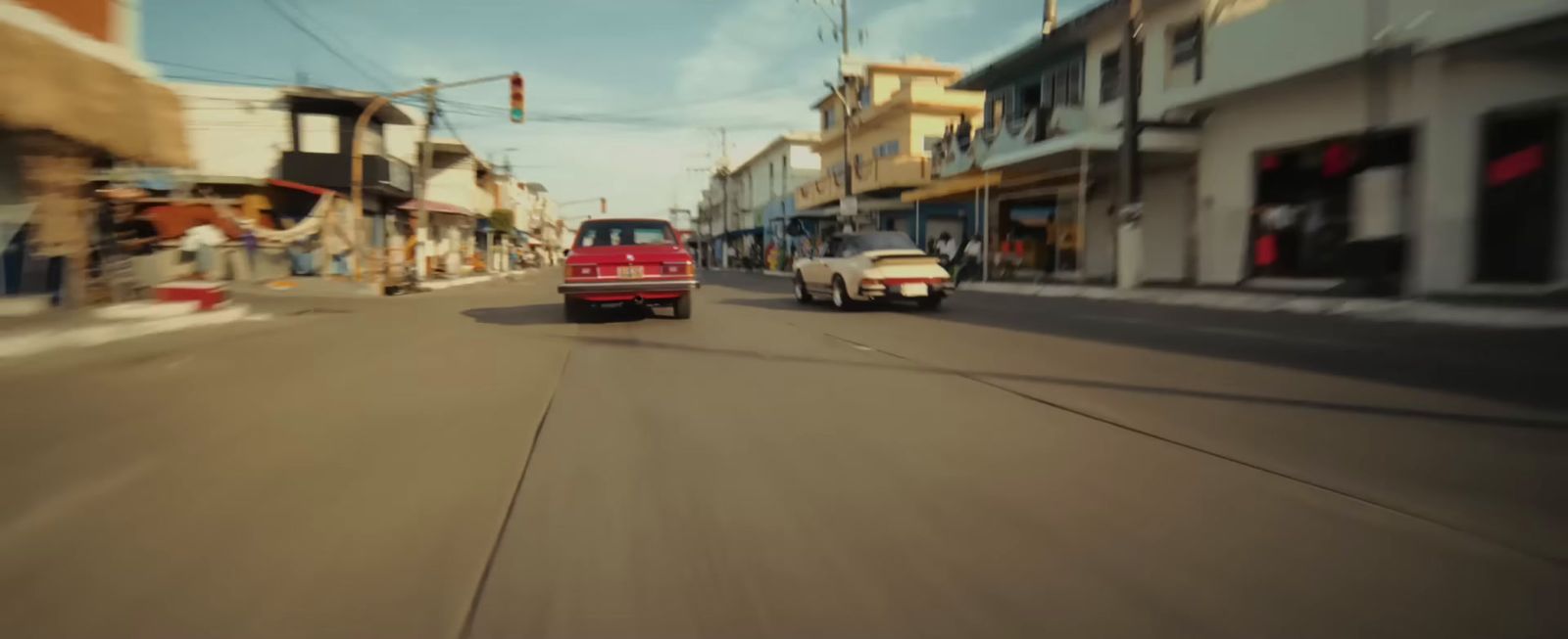 a red truck driving down a street next to tall buildings