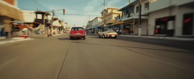 a red truck driving down a street next to tall buildings