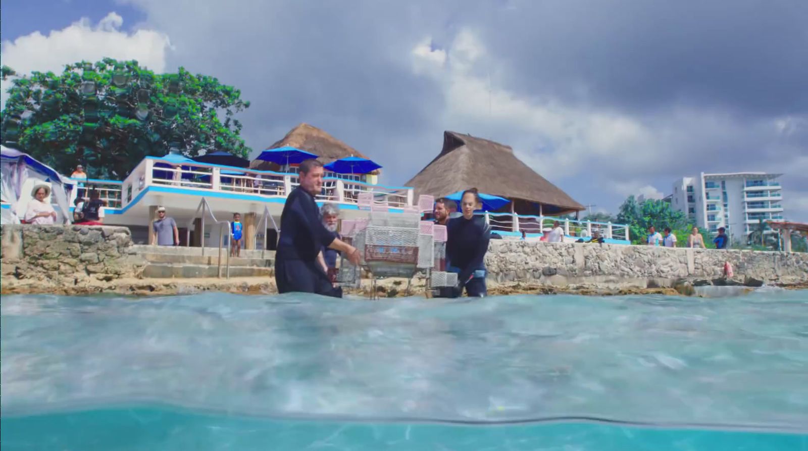 a group of people standing around a body of water