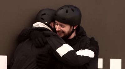 two men hugging each other with helmets on