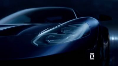 the front of a blue sports car in the dark