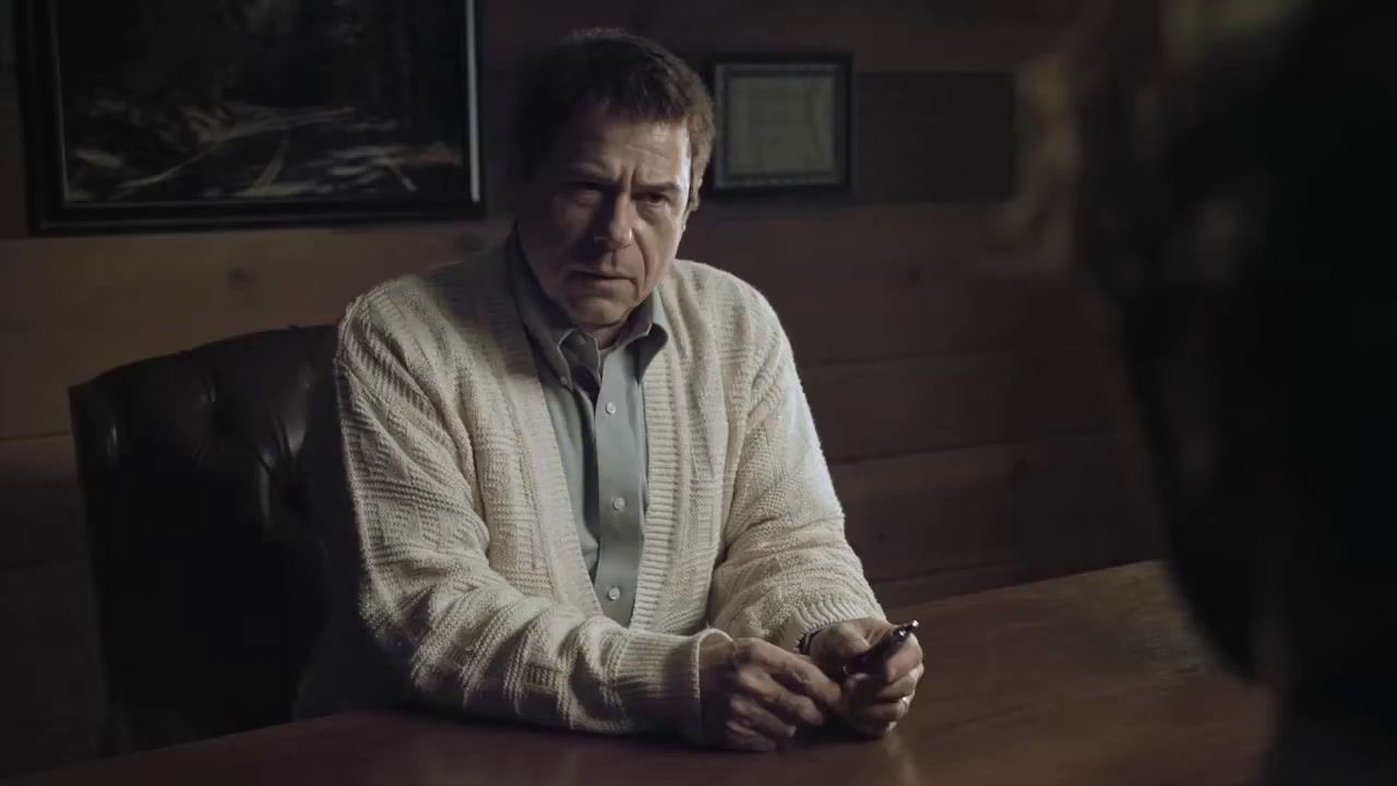 a man sitting at a table looking at his cell phone