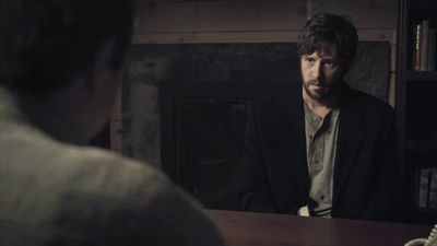 a man sitting at a table in a dark room