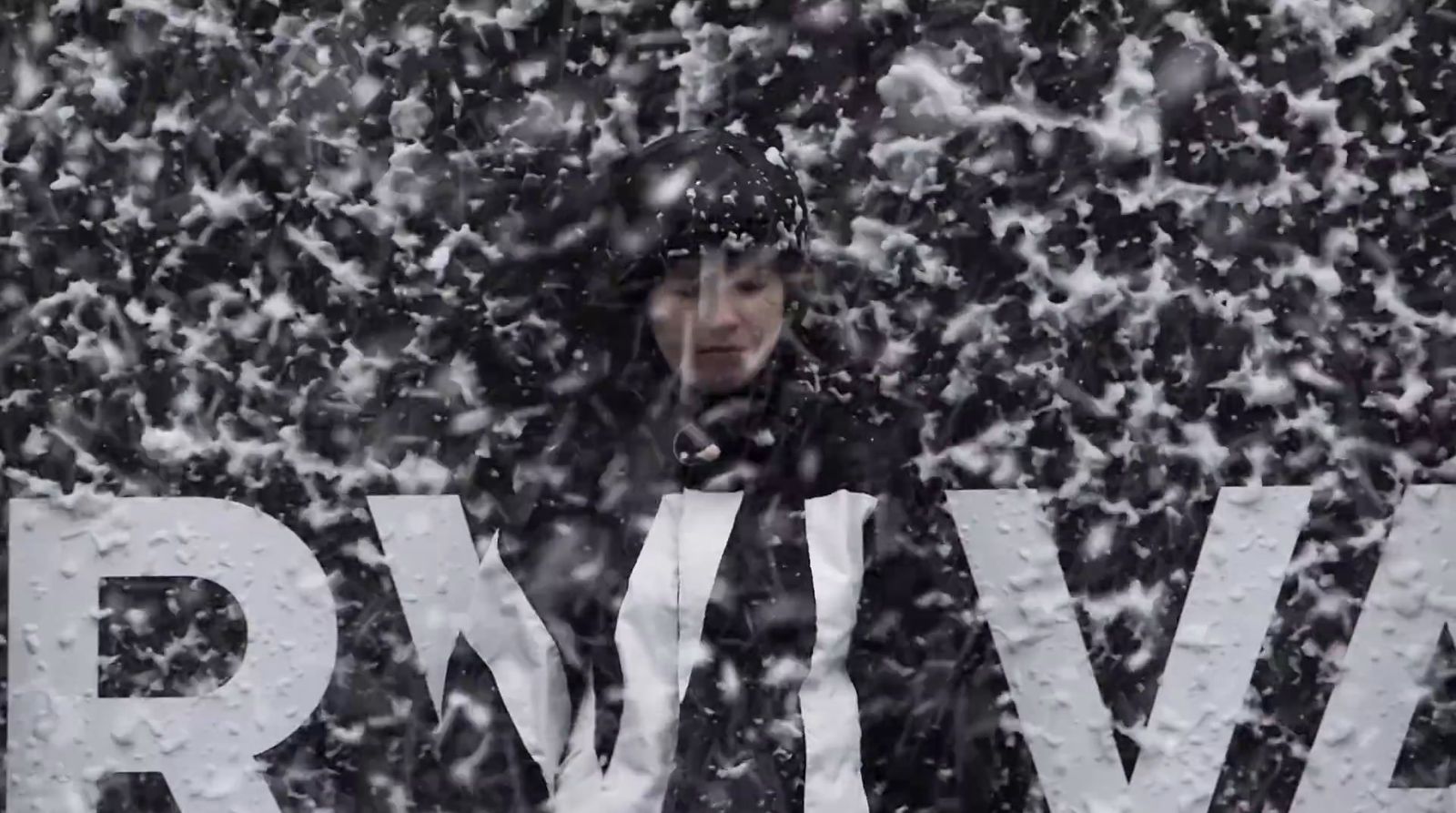 a woman standing in front of a sign covered in snow