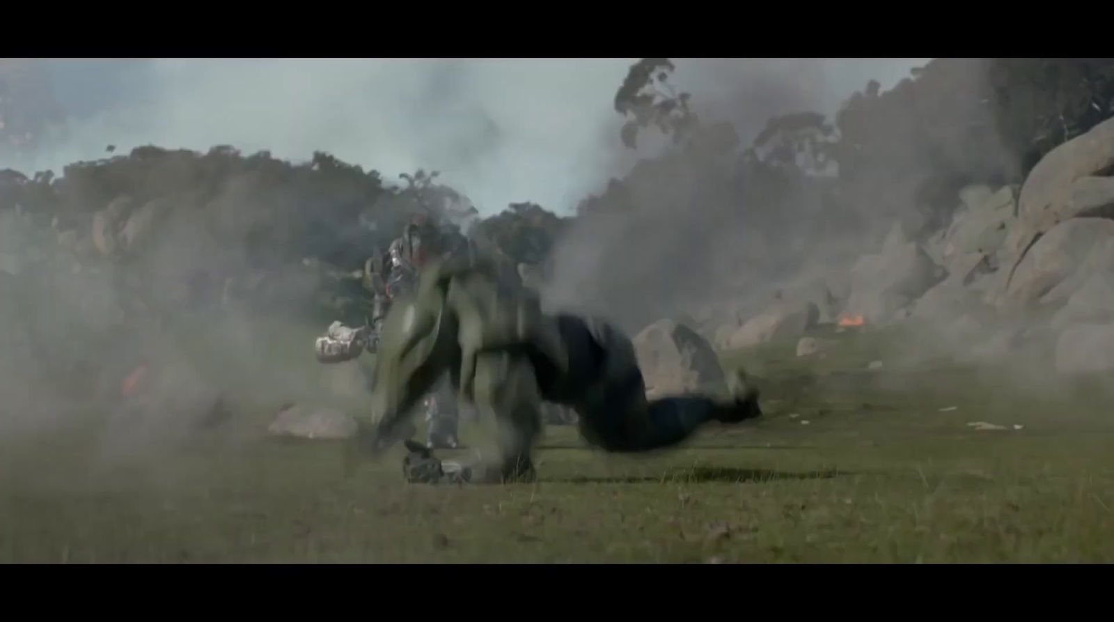 a group of people in a field with smoke coming out of the ground