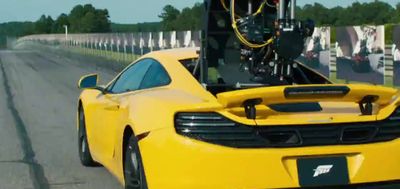 a yellow sports car driving down a road