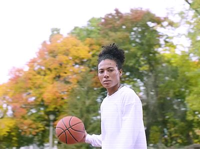 a young man holding a basketball on a basketball court