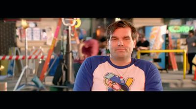 a man in a blue and white shirt standing in front of a playground