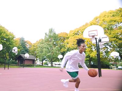 a young man dribbling a basketball on a court