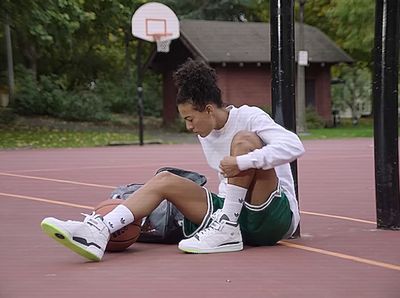 a young man sitting on a basketball court