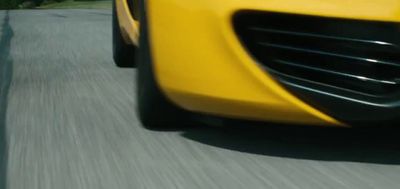 a yellow sports car driving down a street