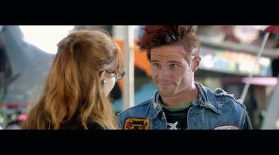 a man with red hair talking to a woman