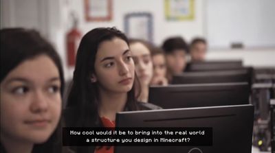 a group of people sitting in front of computers