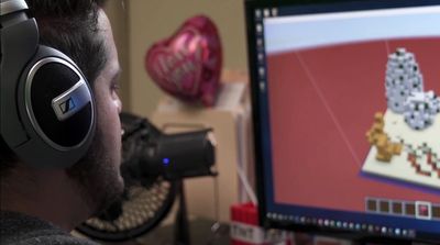 a man wearing headphones looking at a computer screen