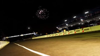 a person riding a motorcycle on a race track at night