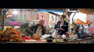 a man and a woman standing at a table with food