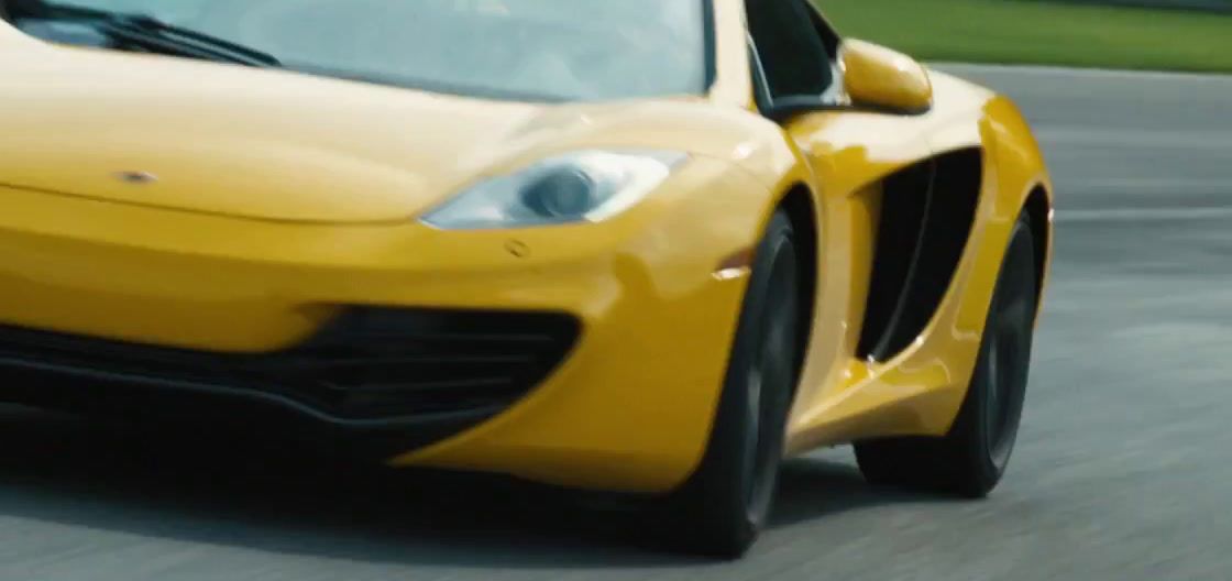 a yellow sports car driving down a race track