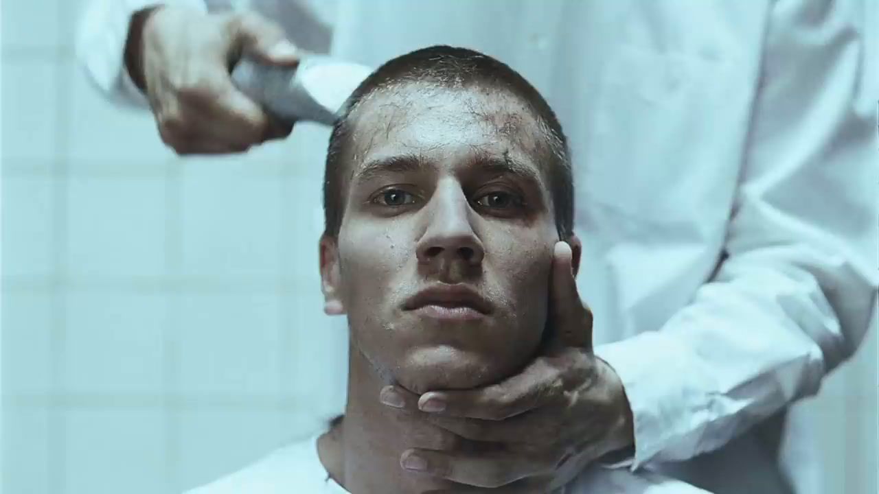 a man is shaving his face in front of a mirror