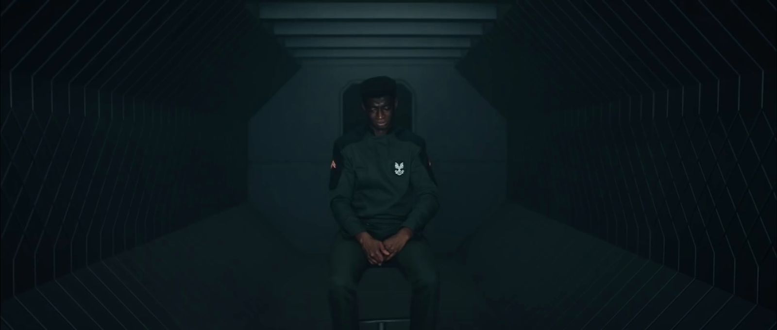 a person sitting in a dark room with a hoodie on