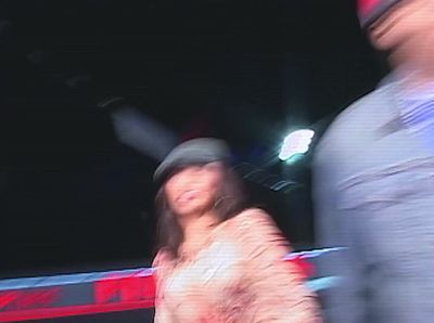 a blurry image of a woman walking past a man