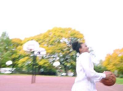 a man holding a basketball in a park