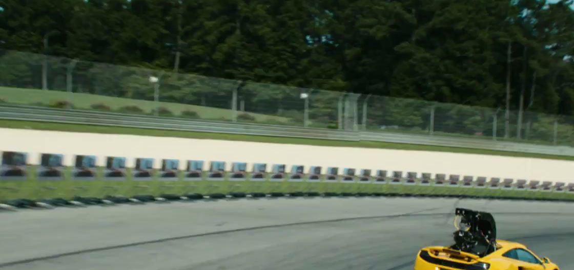 a yellow sports car driving down a race track