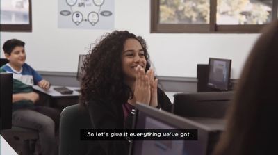 a woman sitting in front of a computer screen