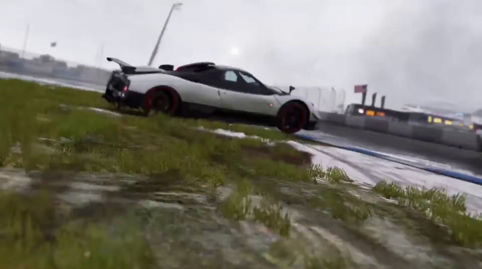 a white sports car driving down a wet road