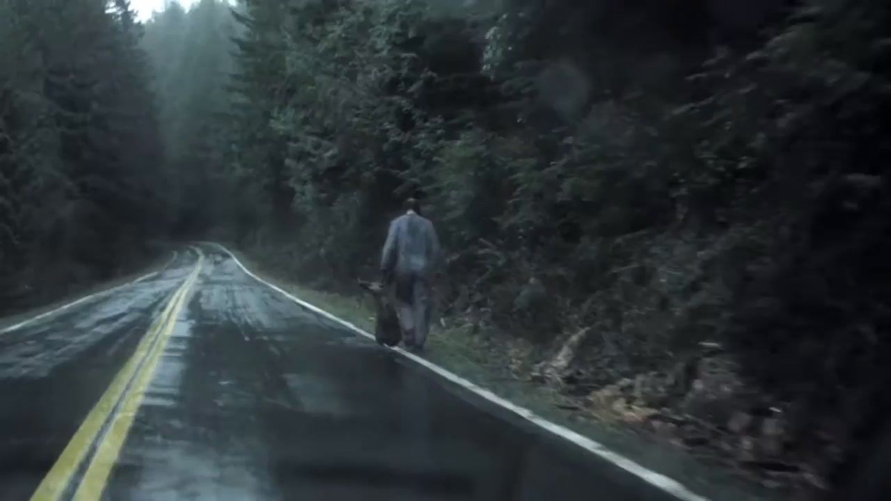 a man walking down the road in the rain