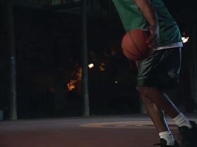 a man holding a basketball on top of a basketball court