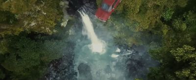 an aerial view of a waterfall and a red truck