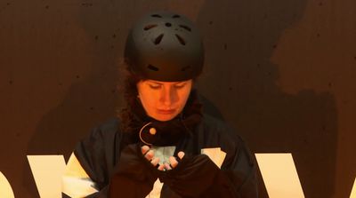 a woman wearing a helmet and holding a cell phone