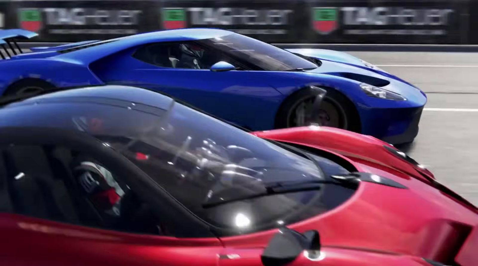 two red and blue sports cars driving down a race track