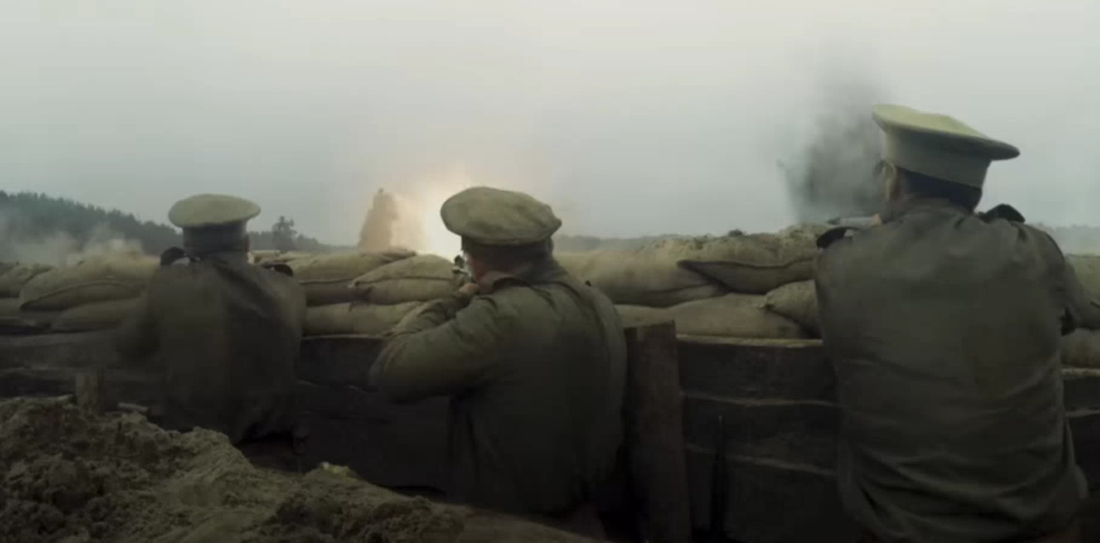 a group of men standing next to a pile of sand