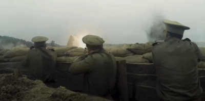 a group of men standing next to a pile of sand