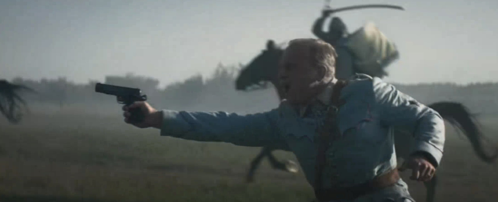 a man holding a gun in a field