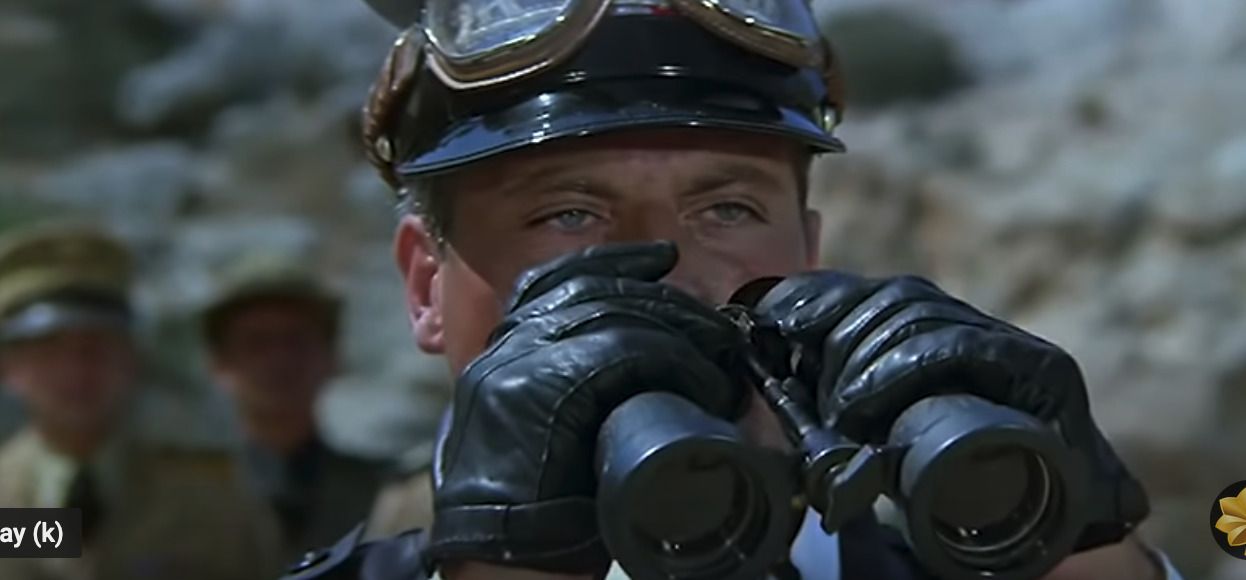 a man wearing a helmet and holding a pair of gloves